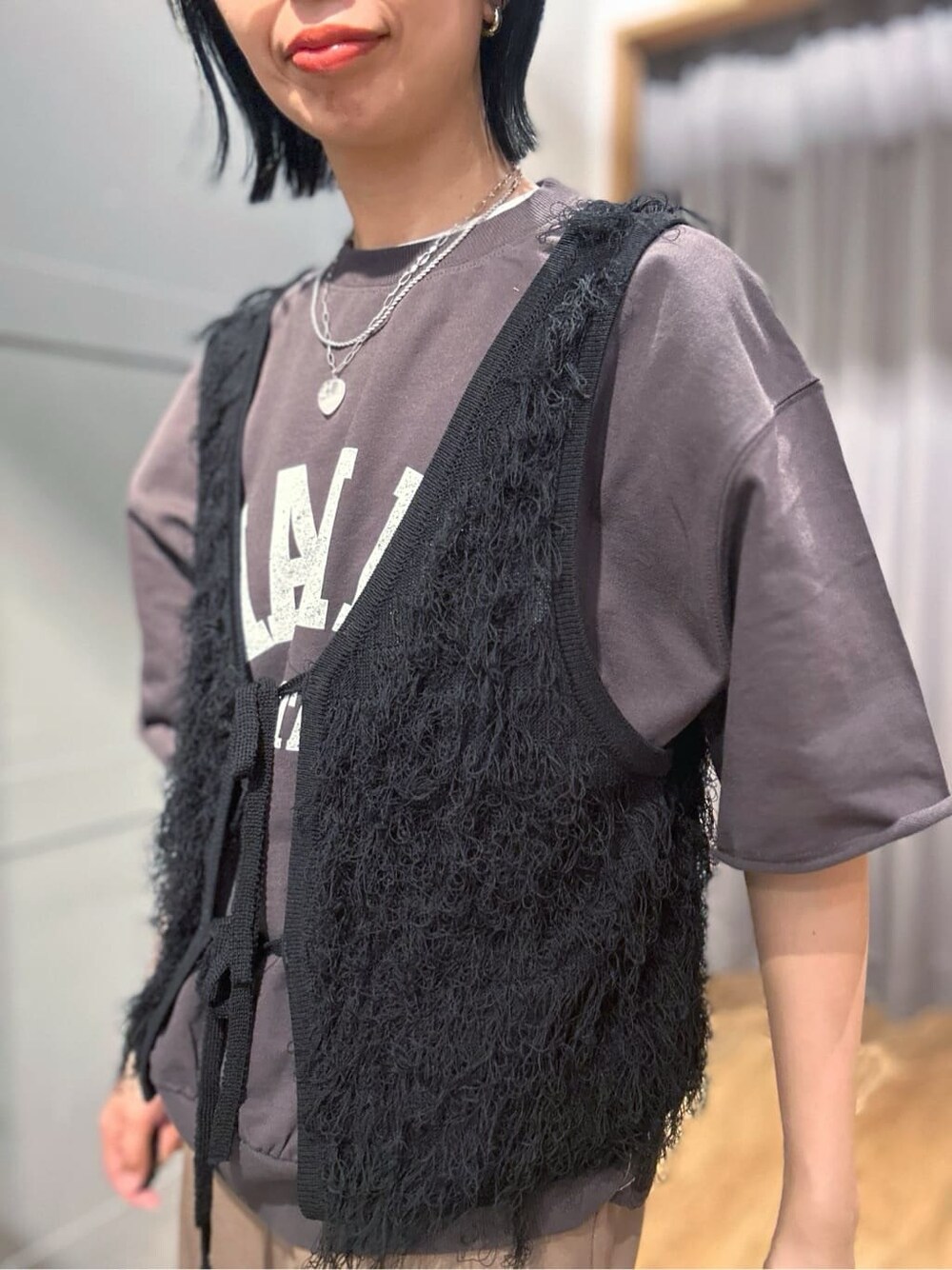グレー系のTシャツ/カットソー、ブラック系のベスト、ブラック系のその他を着用したレディースの春コーディネートの5枚目の写真