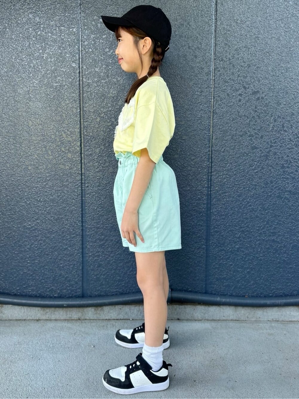 イエロー系のTシャツ/カットソー、グリーン系のその他パンツ、ブラック系のパーカーを着用したレディースの春コーディネートの4枚目の写真