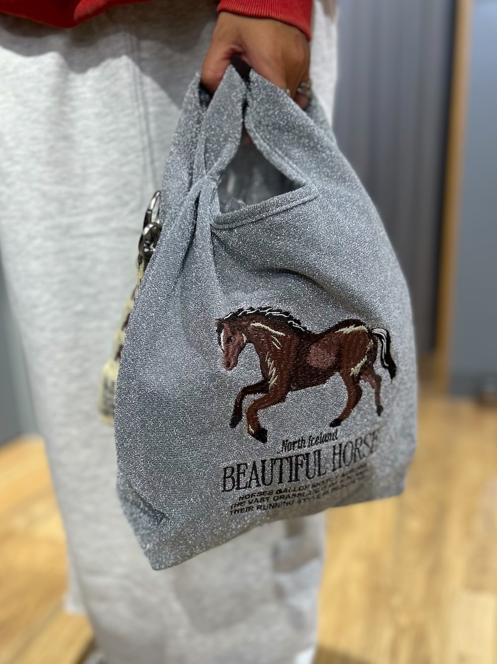 レッド系のスウェット、グレー系のスカート、ブルー系のシャツ/ブラウスを着用したレディースの秋コーディネートの10枚目の写真