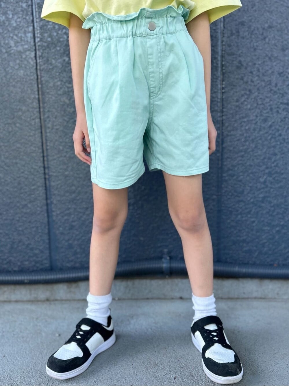 イエロー系のTシャツ/カットソー、グリーン系のその他パンツ、ブラック系のパーカーを着用したレディースの春コーディネートの9枚目の写真