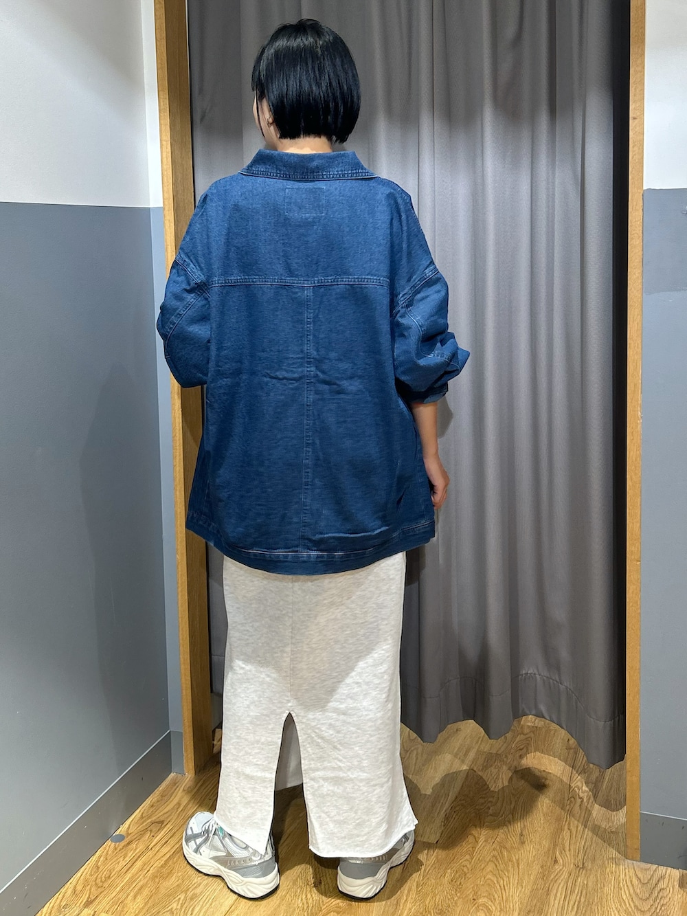 レッド系のスウェット、グレー系のスカート、ブルー系のシャツ/ブラウスを着用したレディースの秋コーディネートの3枚目の写真