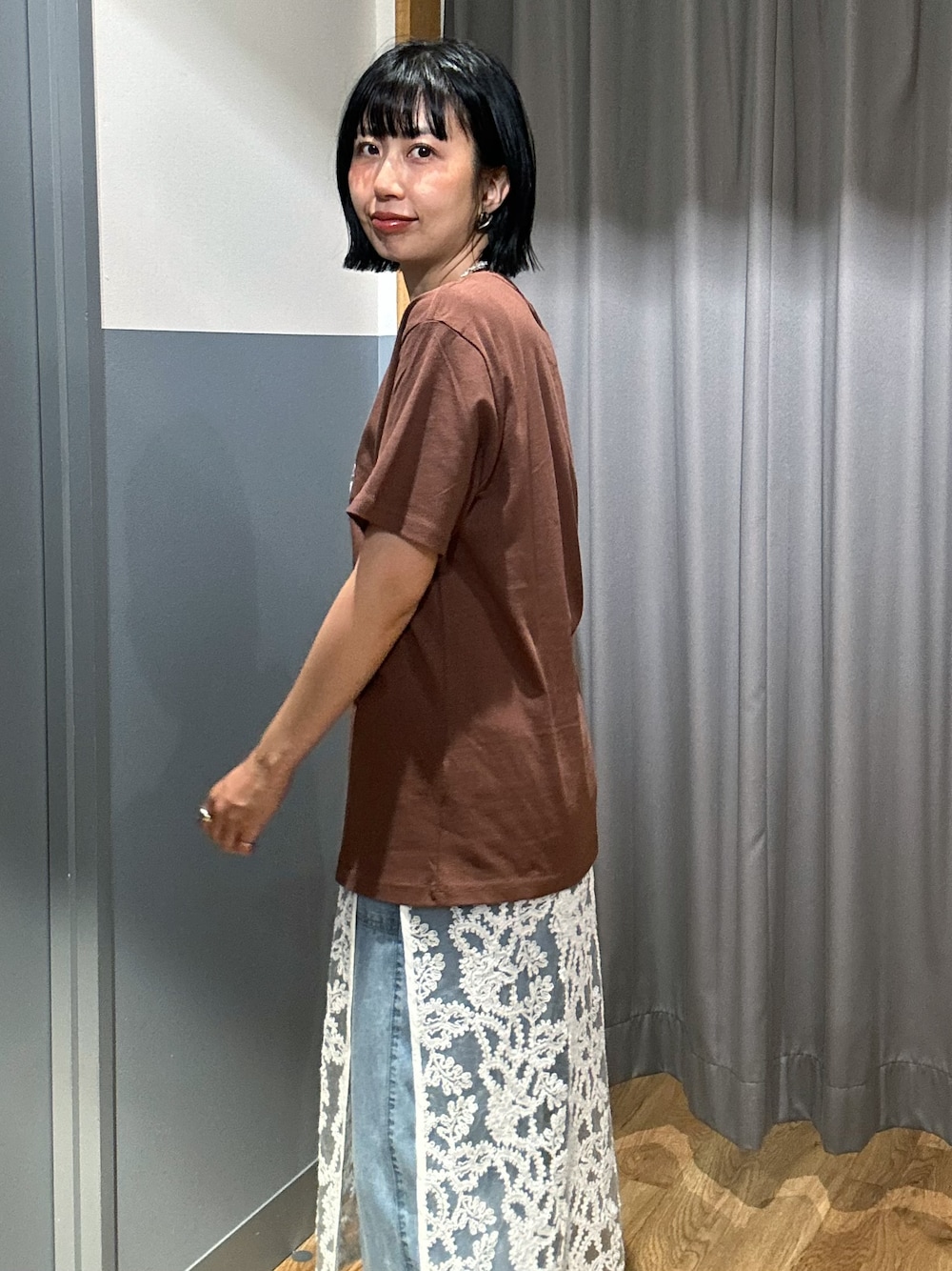 ブラウン系のTシャツ/カットソー、ブルー系のデニムパンツ、ホワイト系のスカートを着用したレディースの夏コーディネートの5枚目の写真