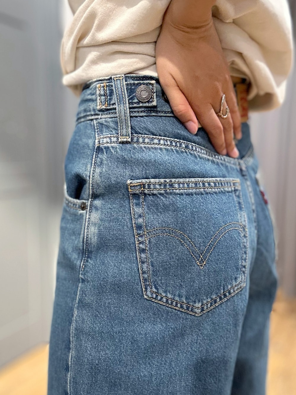 ホワイト系のTシャツ/カットソー、ブルー系のデニムパンツ、ブラウン系のベストを着用したレディースの春コーディネートの8枚目の写真