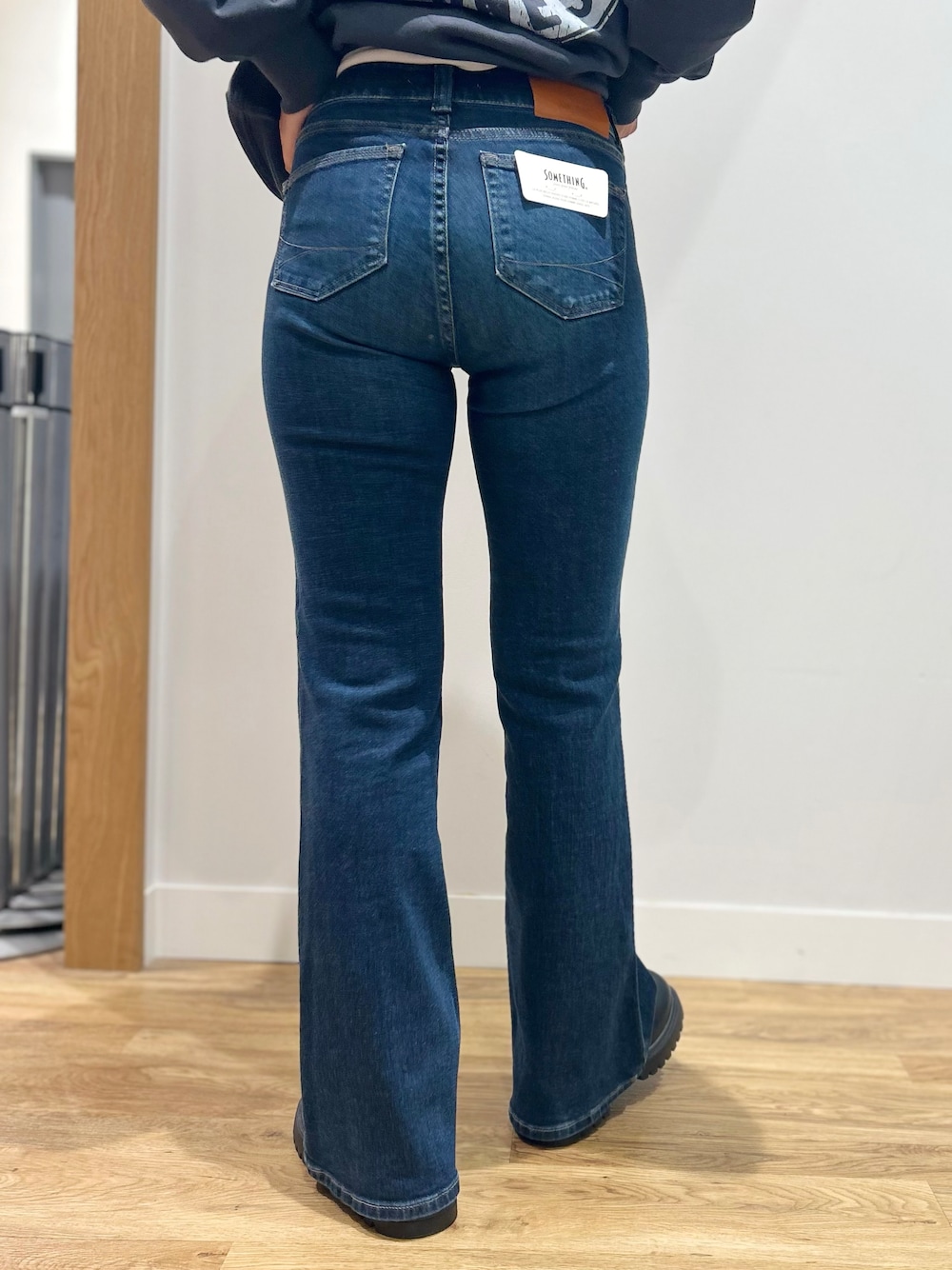 グレー系のスウェット、ホワイト系のTシャツ/カットソー、ブルー系のその他パンツを着用したレディースの秋コーディネートの8枚目の写真