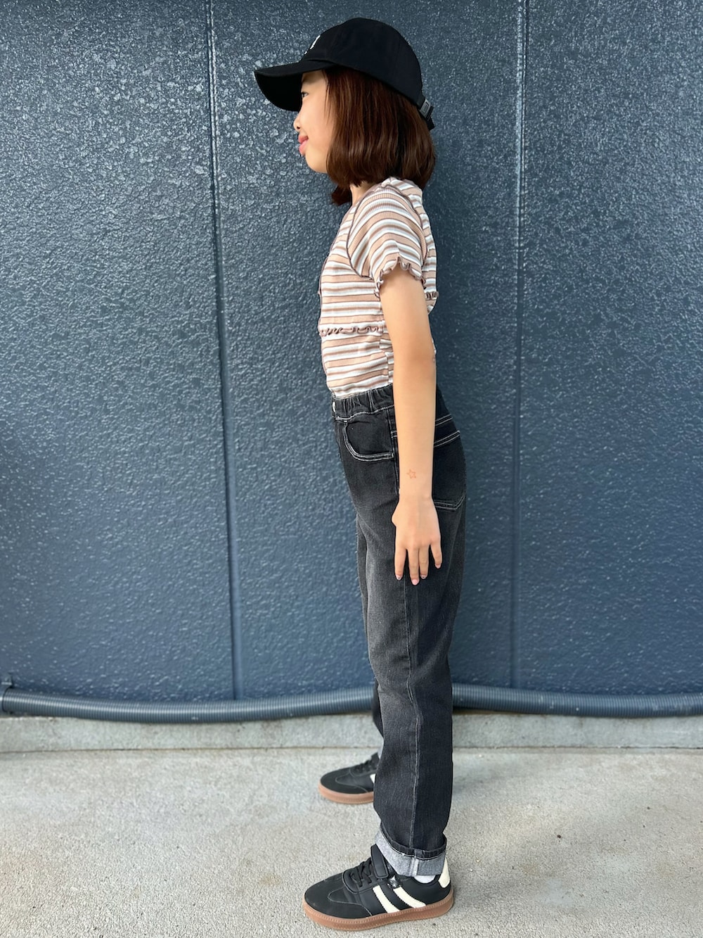 ブラウン系のTシャツ/カットソー、ブラック系のデニムパンツ、ブラック系のキャップを着用したキッズの夏コーディネートの2枚目の写真