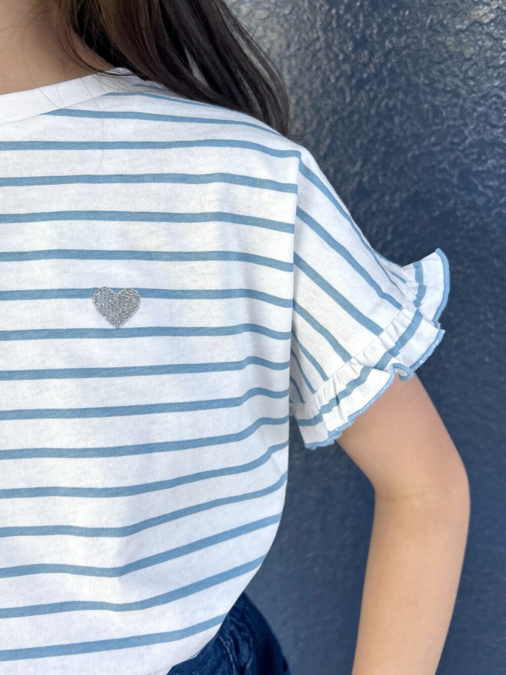 ブルー系のTシャツ/カットソー、ブルー系のデニムパンツ、ブラック系のショルダーバッグを着用したレディースの春コーディネートの6枚目の写真