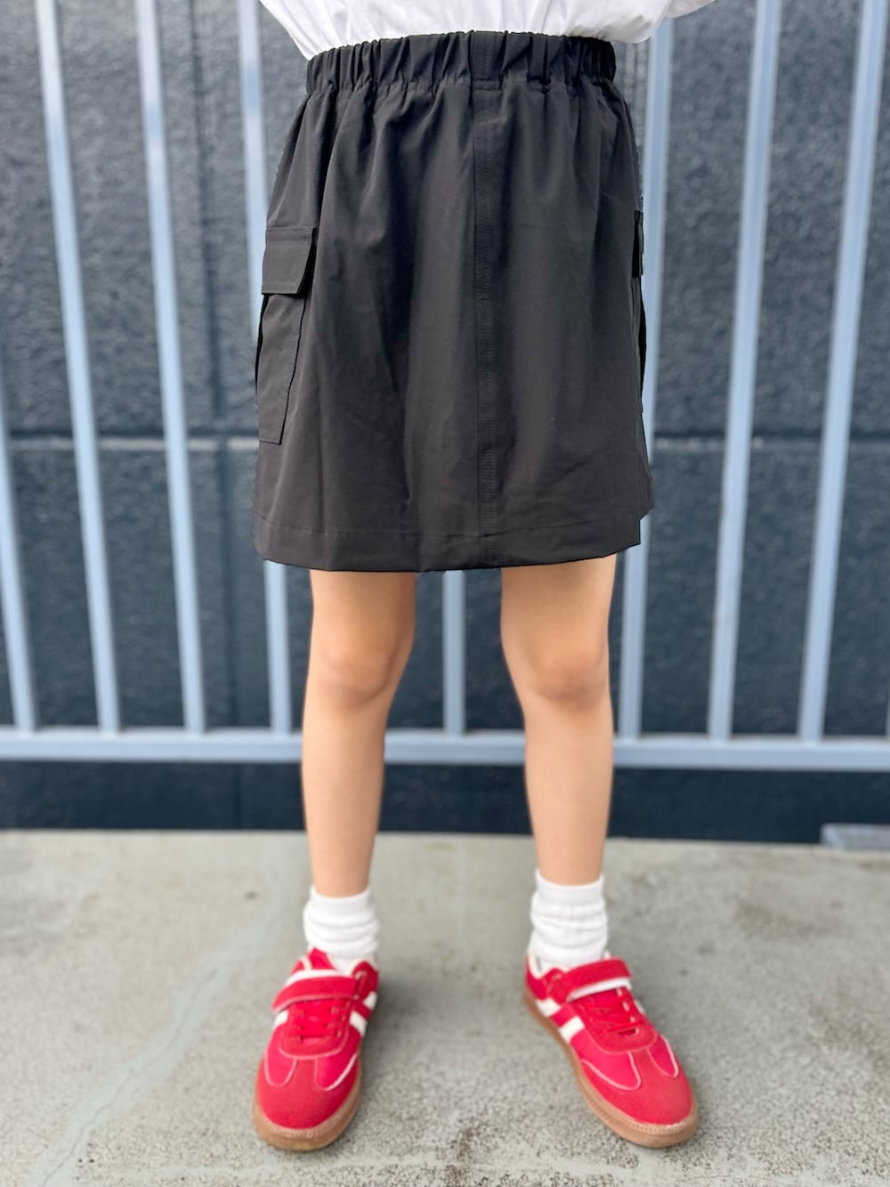 ホワイト系のTシャツ/カットソー、ブラック系のスカートを着用したキッズの夏コーディネートの10枚目の写真