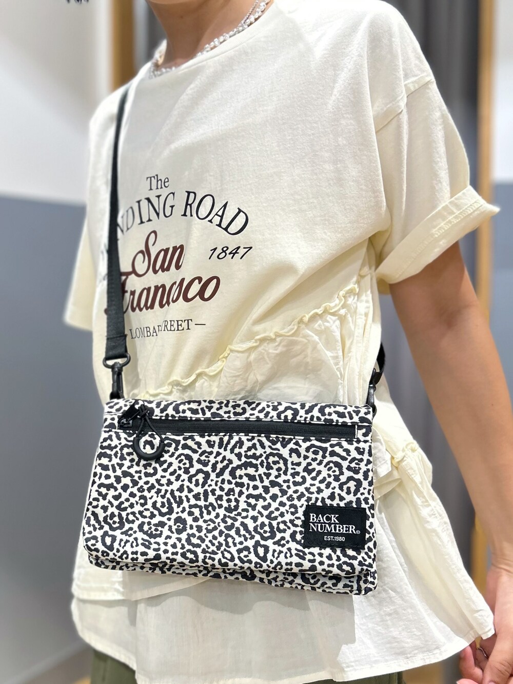 ホワイト系のTシャツ/カットソー、ブラウン系のスカート、ホワイト系のボディバッグ/ウエストポーチを着用したレディースの夏コーディネートの8枚目の写真