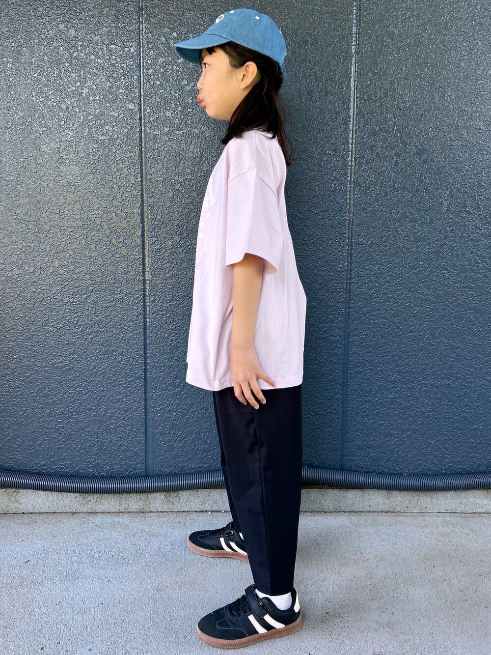 ピンク系のTシャツ/カットソー、ブラック系のその他パンツ、ブルー系のキャップを着用したレディースの春コーディネートの3枚目の写真