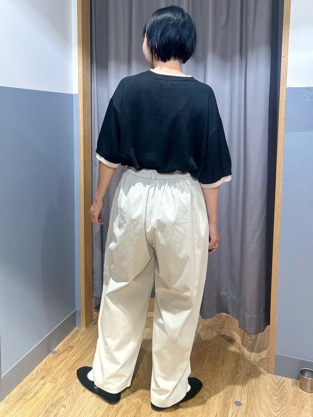 ブラック系のニット/セーター、グレー系のその他パンツ、ブラック系のトートバッグを着用したレディースの夏コーディネートの4枚目の写真