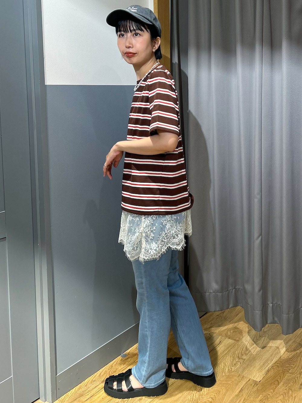 ブルー系のデニムパンツ、ブラック系のショルダーバッグ、ブラック系のキャップを着用したレディースの夏コーディネートの3枚目の写真
