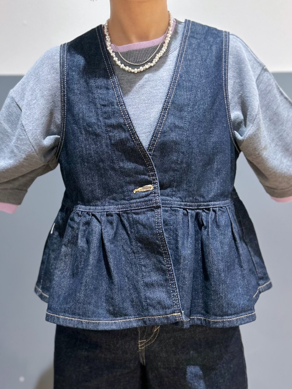 グレー系のニット/セーター、ブルー系のその他トップス、ブルー系のデニムパンツを着用したレディースの夏コーディネートの4枚目の写真