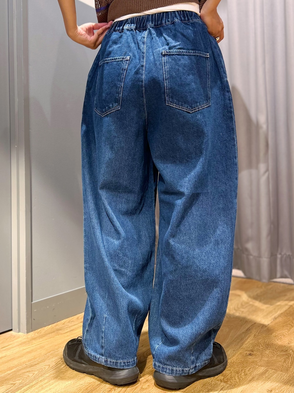 グレー系のニット/セーター、ブルー系のその他パンツ、ベージュ系のショルダーバッグを着用したレディースの夏コーディネートの6枚目の写真