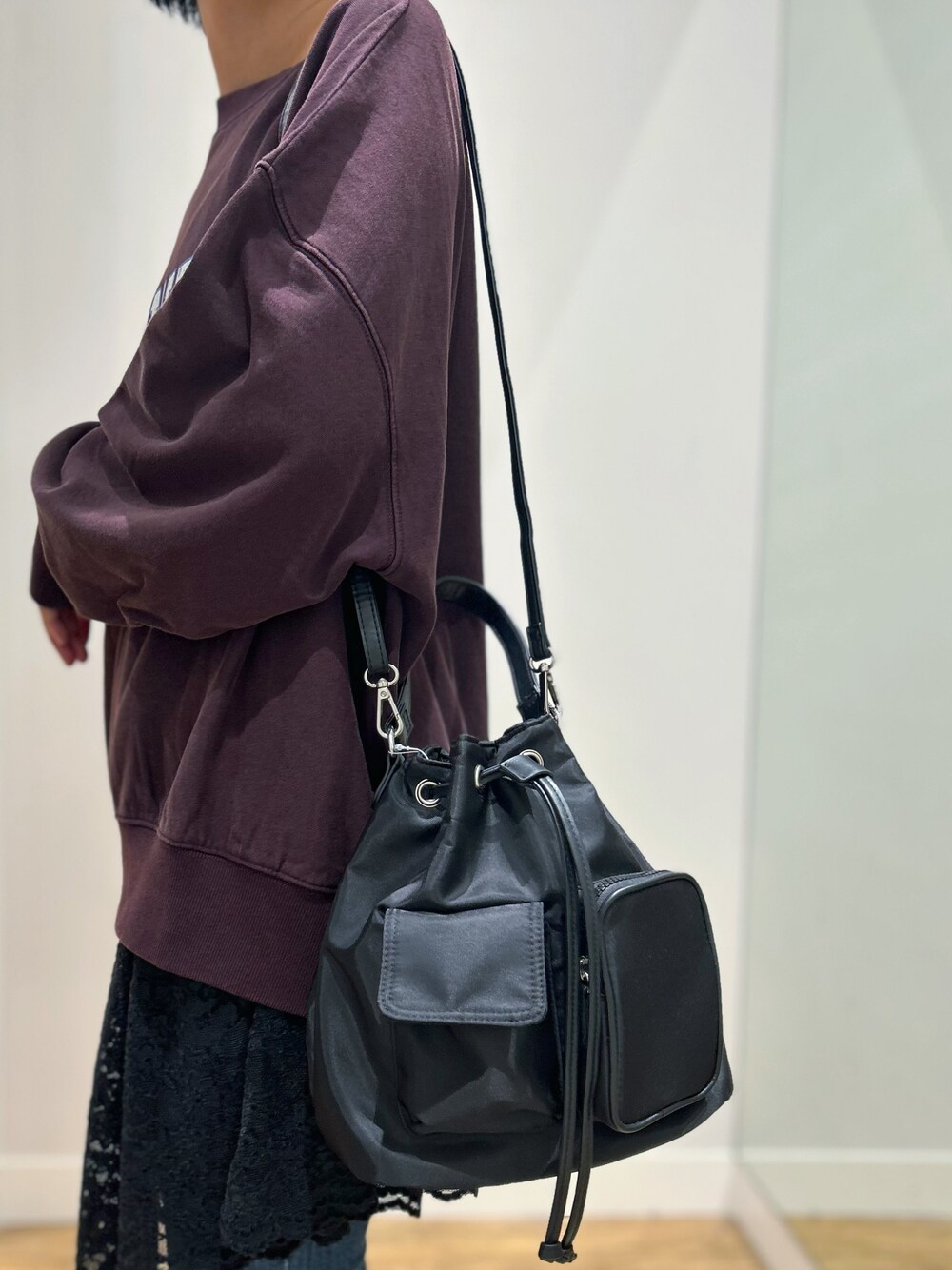 レッド系のスウェット、ブルー系のその他パンツ、ブラック系のショルダーバッグを着用したレディースの秋コーディネートの5枚目の写真