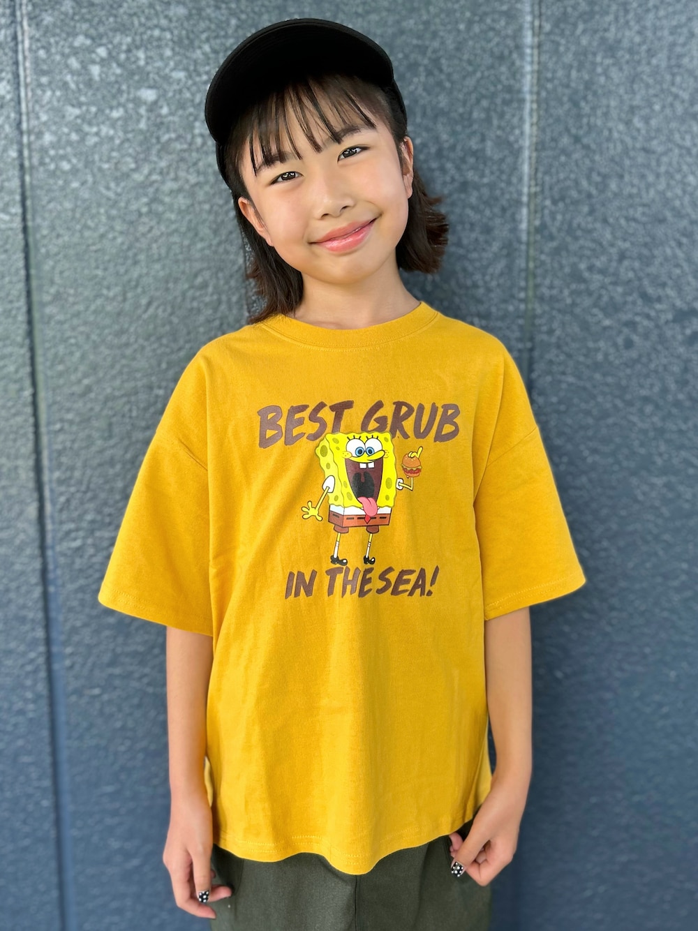 イエロー系のニット/セーター、ブラウン系のその他パンツ、ブラック系のキャップを着用したキッズの夏コーディネートの4枚目の写真