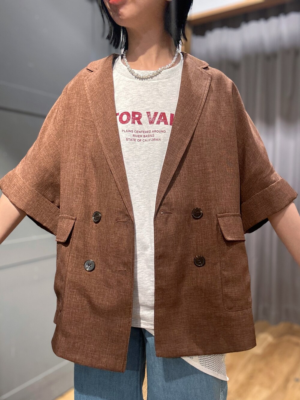 ブラウン系のテーラードジャケット、ブラック系のショルダーバッグ、グレー系のTシャツ/カットソーを着用したレディースの春コーディネートの4枚目の写真