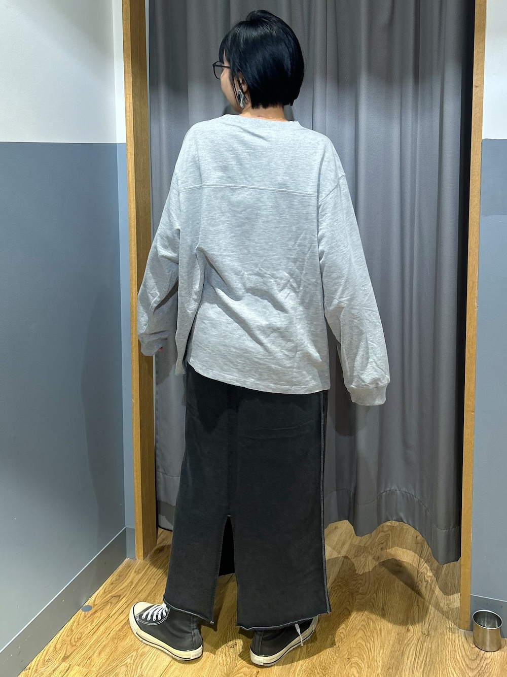グレー系のTシャツ/カットソー、グレー系のスカート、ブラック系のボディバッグ/ウエストポーチを着用したレディースの秋コーディネートの3枚目の写真