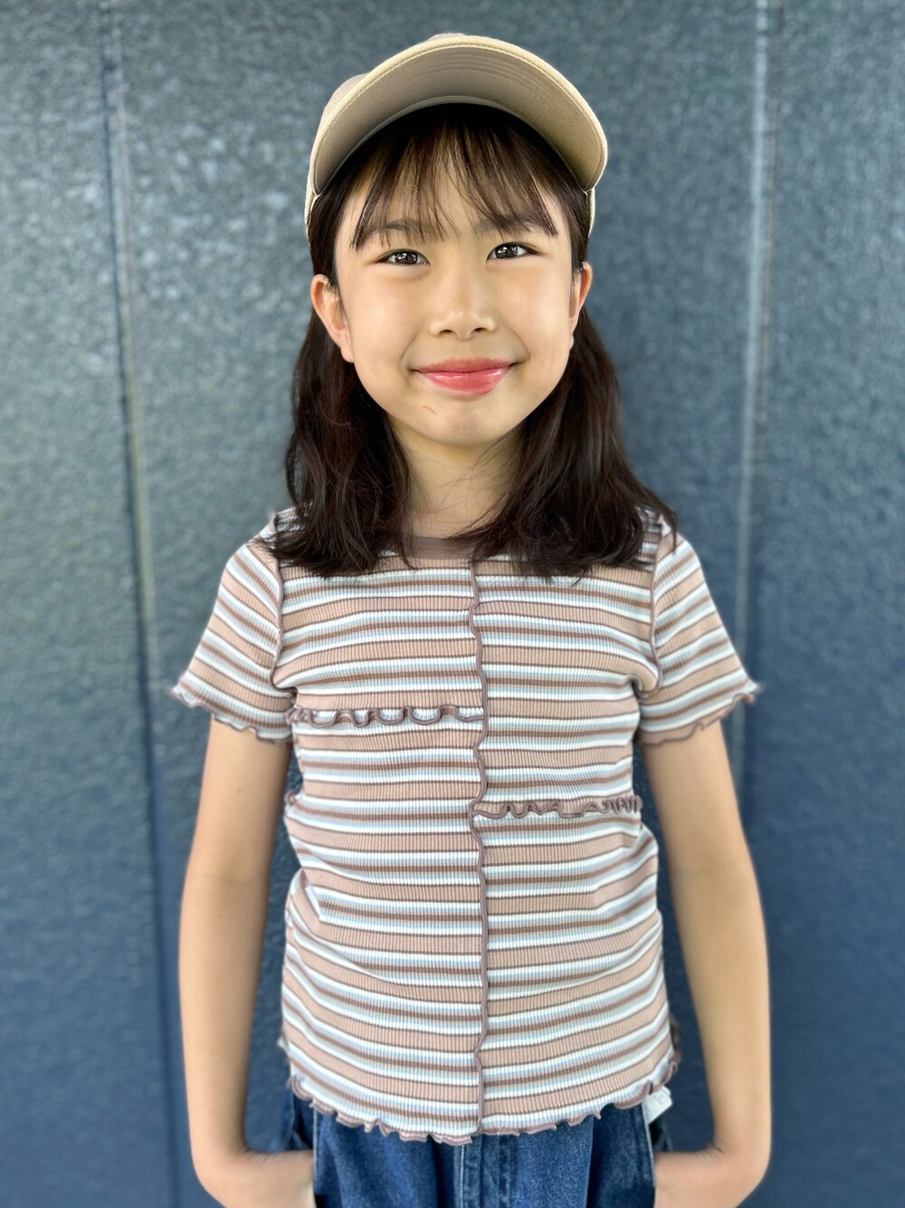 ブルー系のデニムパンツ、ブラウン系のTシャツ/カットソー、ベージュ系のキャップを着用したキッズの夏コーディネートの4枚目の写真