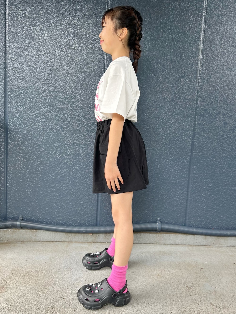 ホワイト系のTシャツ/カットソー、ブラック系のスカート、パープル系のショルダーバッグを着用したレディースの春コーディネートの2枚目の写真