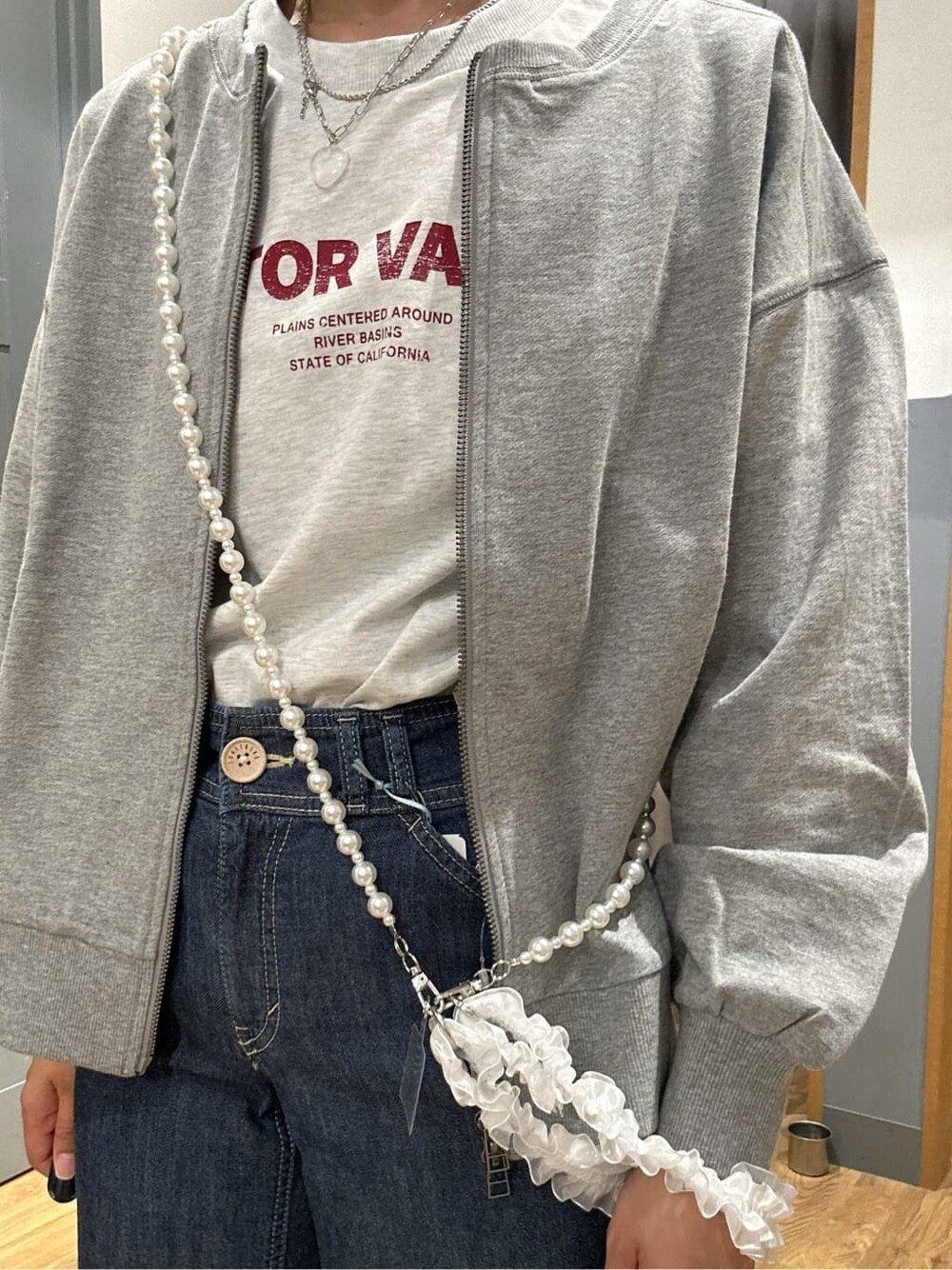 グレー系のTシャツ/カットソー、グレー系のカーディガン/ボレロ、ブルー系のデニムパンツを着用したレディースの春コーディネートの10枚目の写真