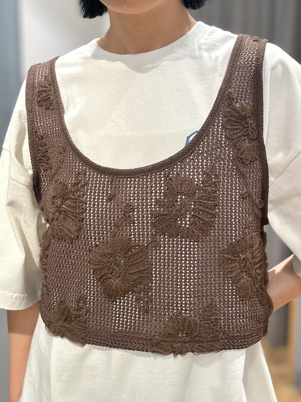 ブラウン系のベスト、ブルー系のスカート、ブラウン系のキャップを着用したレディースの夏コーディネートの4枚目の写真