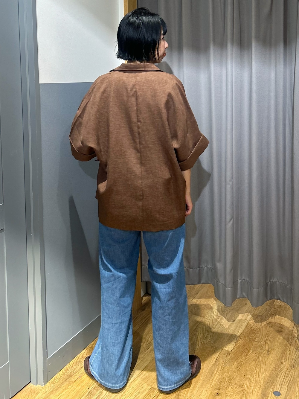 オレンジ系のTシャツ/カットソー、ブラウン系のテーラードジャケット、ブルー系のデニムパンツを着用したレディースの夏コーディネートの4枚目の写真