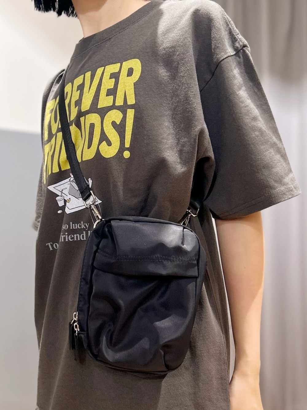 グレー系のTシャツ/カットソー、グリーン系のスカート、ブラック系のショルダーバッグを着用したレディースの夏コーディネートの8枚目の写真