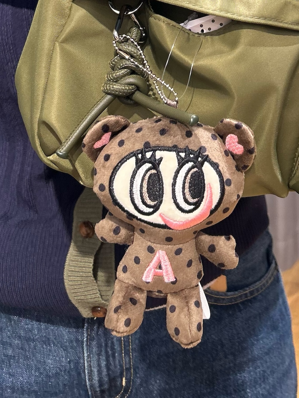 ブルー系のニット/セーター、ブルー系のデニムパンツ、グリーン系のショルダーバッグを着用したレディースの秋コーディネートの8枚目の写真