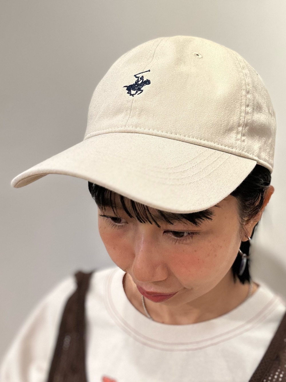 ホワイト系のTシャツ/カットソー、ブルー系のデニムパンツ、ブラウン系のベストを着用したレディースの春コーディネートの9枚目の写真