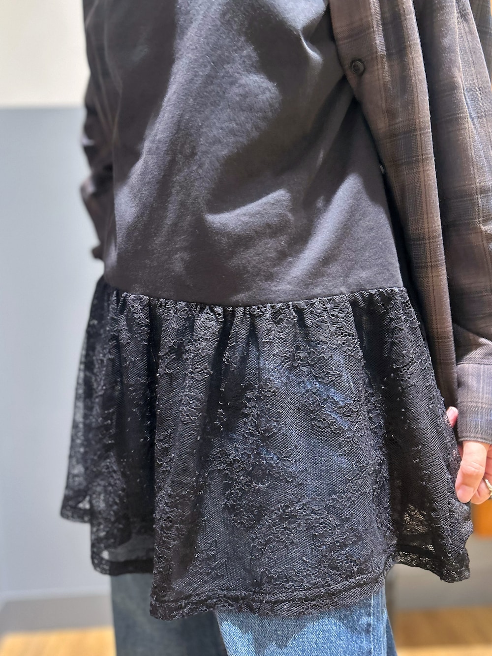 ブラウン系のシャツ/ブラウス、ブラック系のタンクトップ、ブルー系のデニムパンツを着用したレディースの秋コーディネートの6枚目の写真
