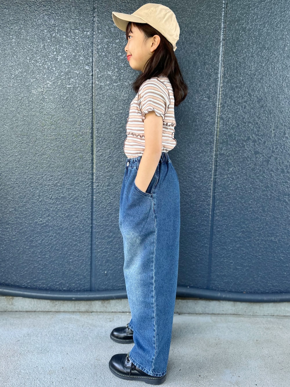 ブルー系のデニムパンツ、ブラウン系のTシャツ/カットソー、ベージュ系のキャップを着用したキッズの夏コーディネートの2枚目の写真