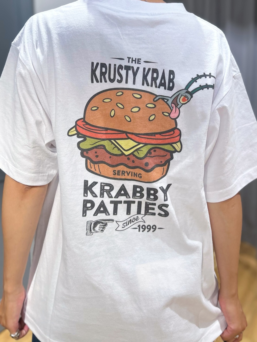 ホワイト系のTシャツ/カットソー、ブラウン系のシャツ/ブラウス、ブルー系のデニムパンツを着用したレディースの夏コーディネートの6枚目の写真