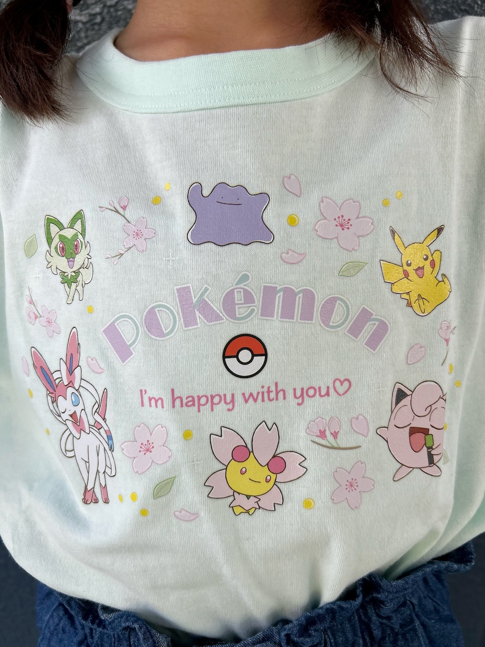 グリーン系のTシャツ/カットソー、ブルー系のデニムスカート、ブラック系のキャップを着用したキッズの夏コーディネートの6枚目の写真