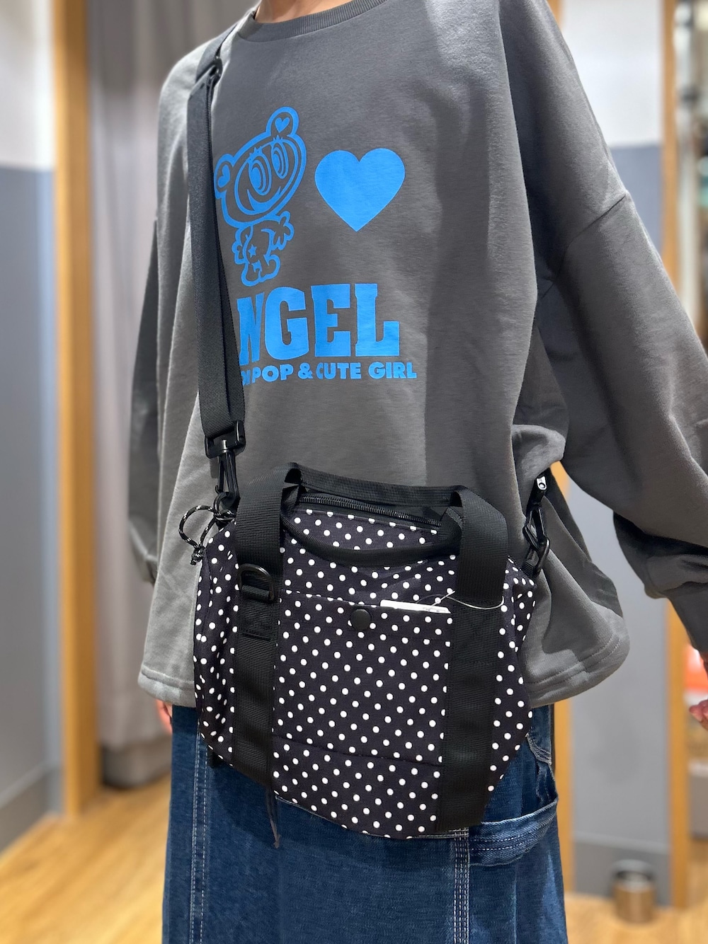 グレー系のニット/セーター、ブルー系のスカート、ブラック系のボストンバッグを着用したレディースの秋コーディネートの10枚目の写真