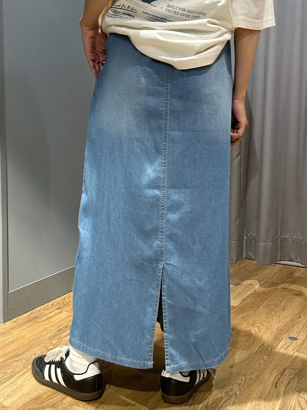 ブラウン系のベスト、ブルー系のスカート、ブラウン系のキャップを着用したレディースの夏コーディネートの8枚目の写真
