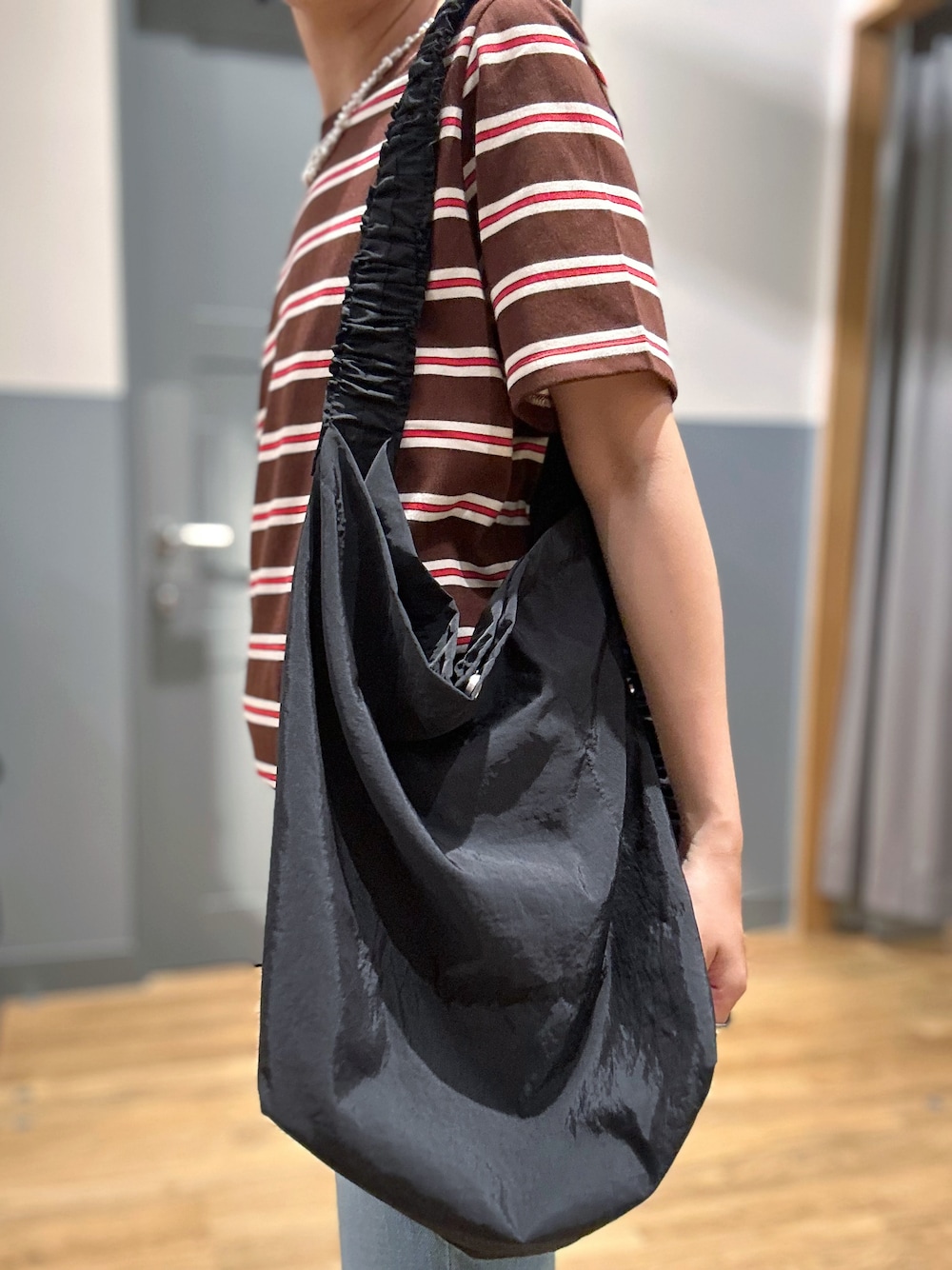 ブルー系のデニムパンツ、ブラック系のショルダーバッグ、ブラック系のキャップを着用したレディースの夏コーディネートの10枚目の写真