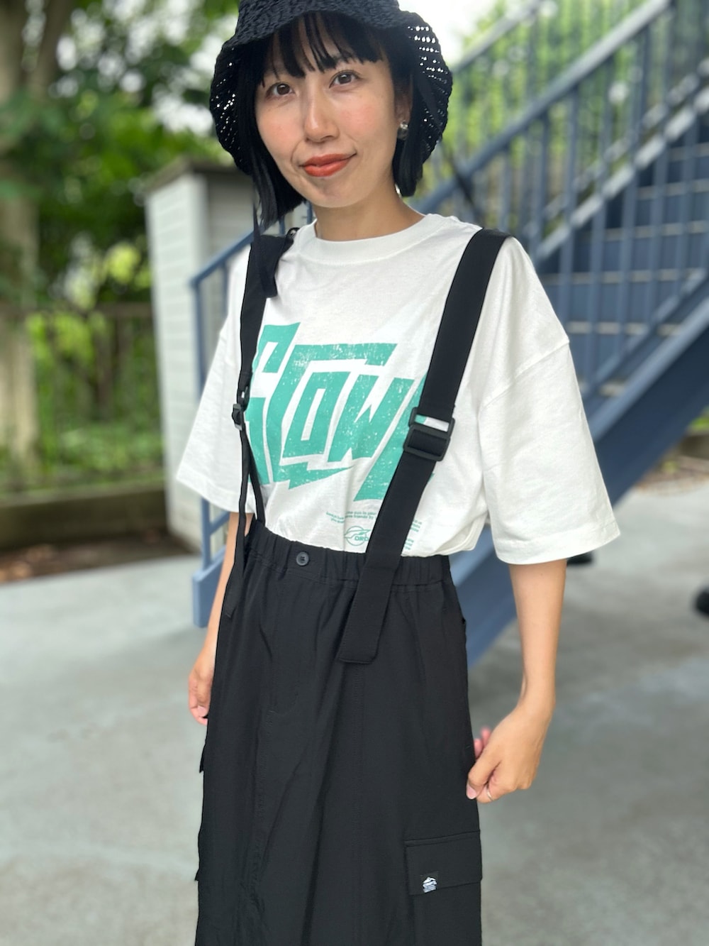 ホワイト系のTシャツ/カットソー、ブラック系のスカート、ブラック系のハットを着用したレディースの春コーディネートの7枚目の写真
