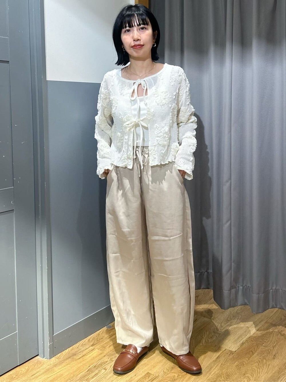 ホワイト系のカーディガン/ボレロ、ホワイト系のタンクトップ、ベージュ系のその他パンツを着用したレディースの春コーディネートの2枚目の写真