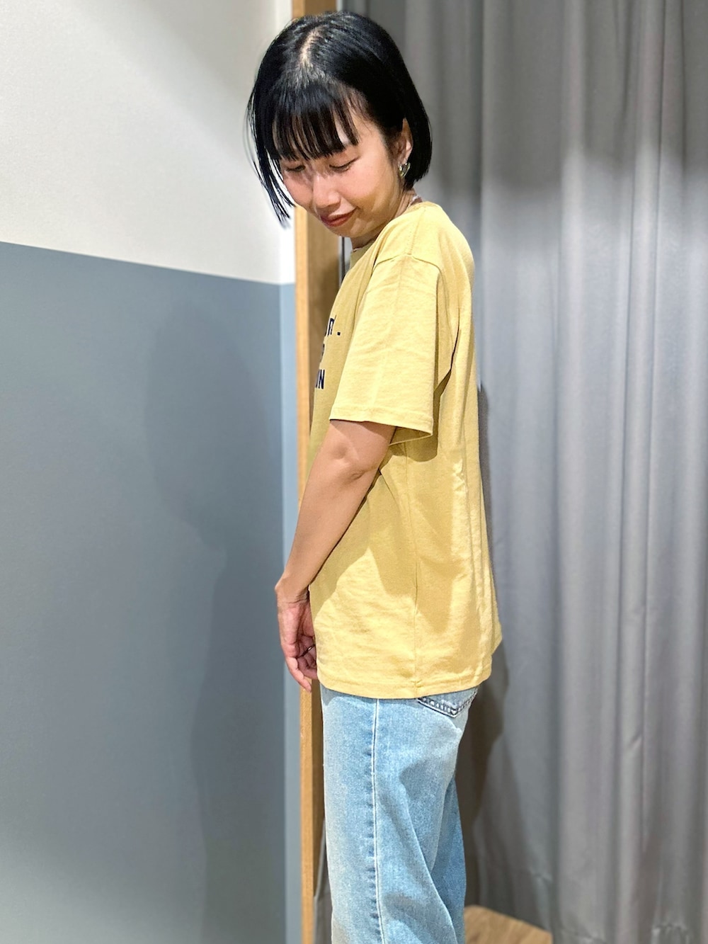 ブラウン系のベスト、ブルー系のデニムパンツ、ベージュ系のトートバッグを着用したレディースの夏コーディネートの7枚目の写真