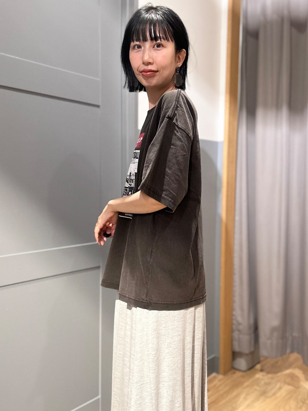 グレー系のスカート、グレー系のシャツ/ブラウス、ブラック系のキャップを着用したレディースの夏コーディネートの4枚目の写真
