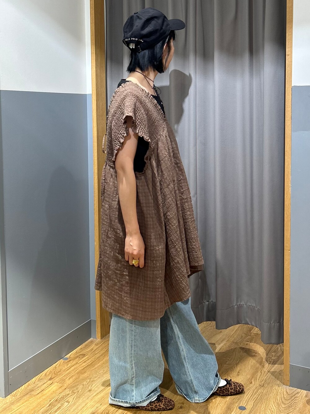 ブルー系のデニムパンツ、ブラック系のキャップを着用したレディースの夏コーディネートの2枚目の写真