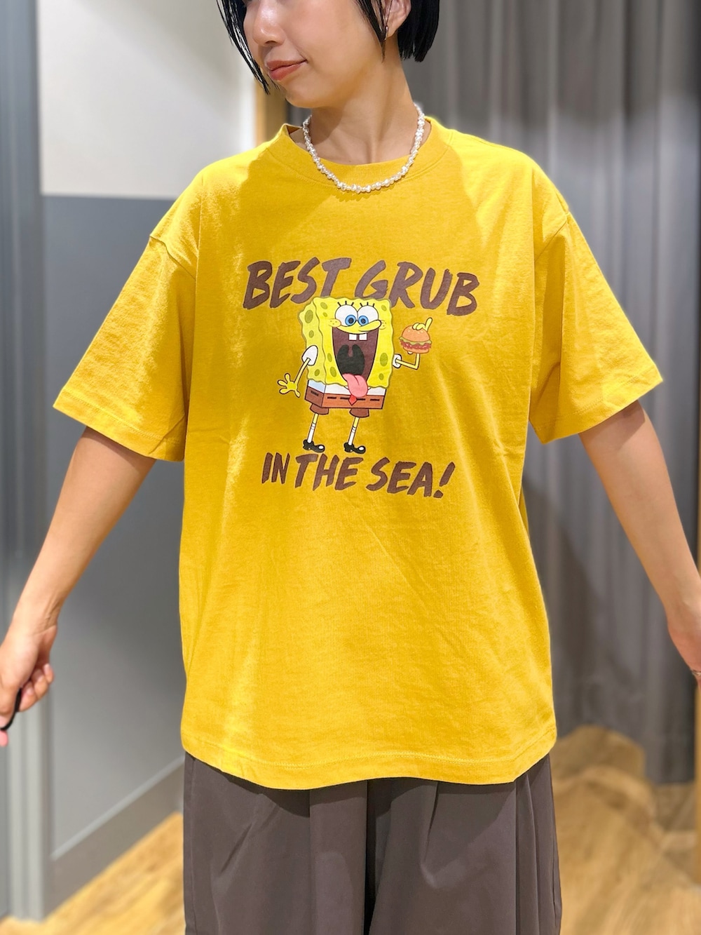 イエロー系のTシャツ/カットソー、グレー系のその他パンツ、ベージュ系のトートバッグを着用したレディースの夏コーディネートの4枚目の写真