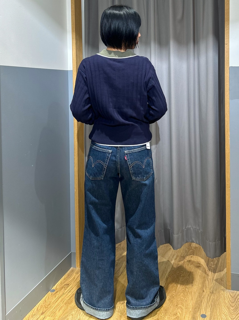 ブルー系のニット/セーター、ブルー系のデニムパンツ、グリーン系のショルダーバッグを着用したレディースの秋コーディネートの3枚目の写真