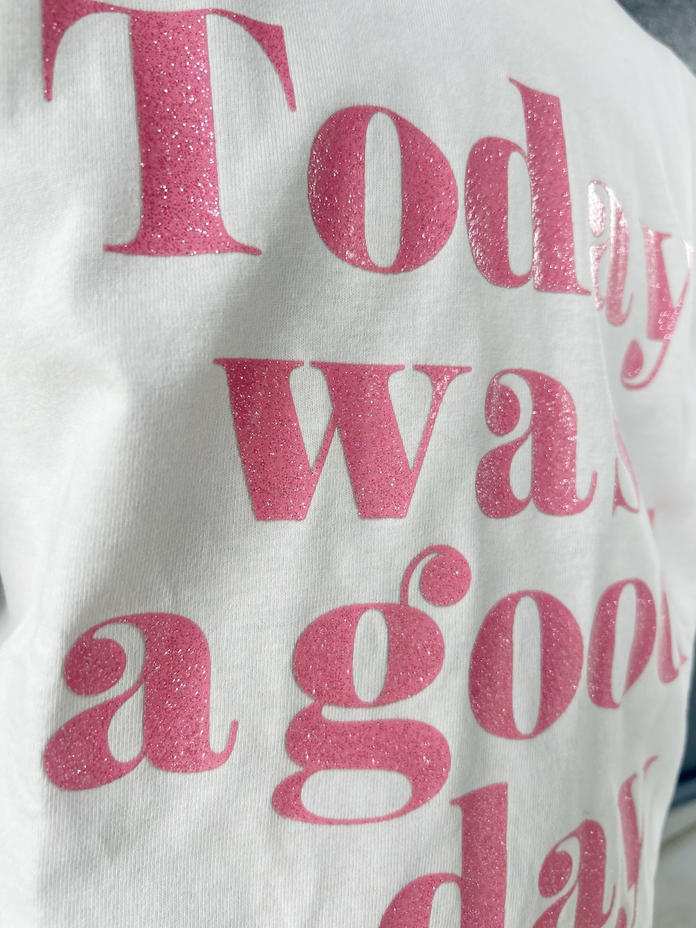 ホワイト系のTシャツ/カットソー、ブラック系のスカート、パープル系のショルダーバッグを着用したレディースの春コーディネートの8枚目の写真