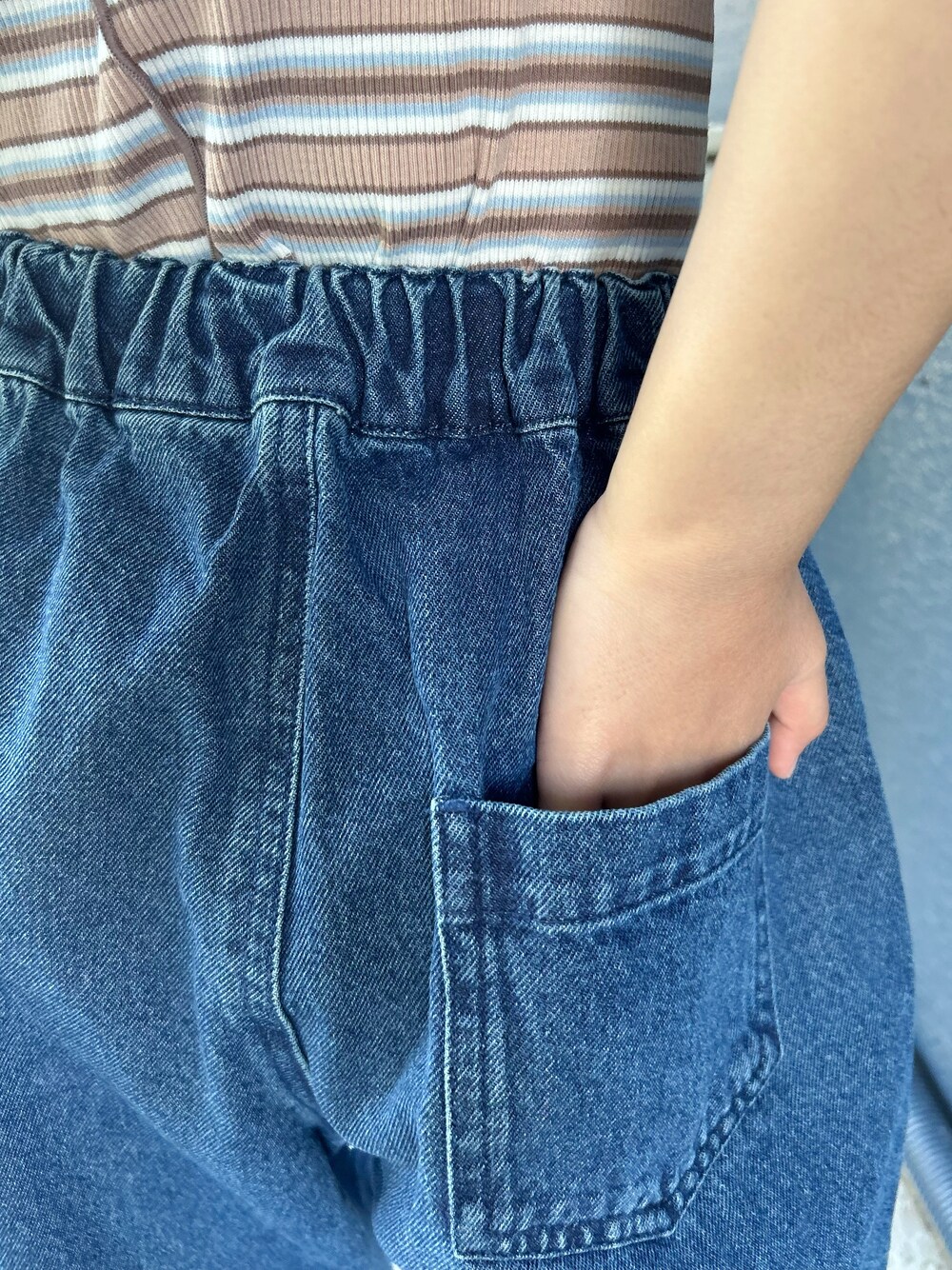 ブルー系のデニムパンツ、ブラウン系のTシャツ/カットソー、ベージュ系のキャップを着用したキッズの夏コーディネートの6枚目の写真