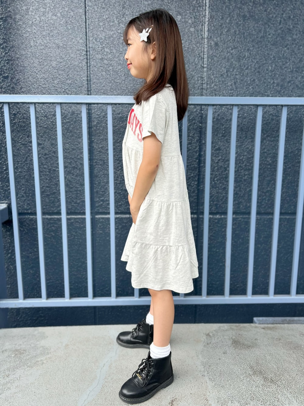 シルバー系のショルダーバッグ、ホワイト系のルームワンピースを着用したキッズの夏コーディネートの3枚目の写真