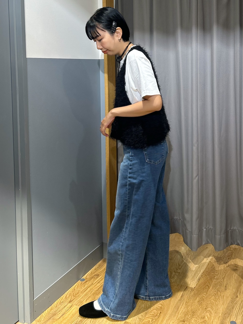 ホワイト系のTシャツ/カットソー、ブラック系のベスト、ブルー系のデニムパンツを着用したレディースの夏コーディネートの2枚目の写真