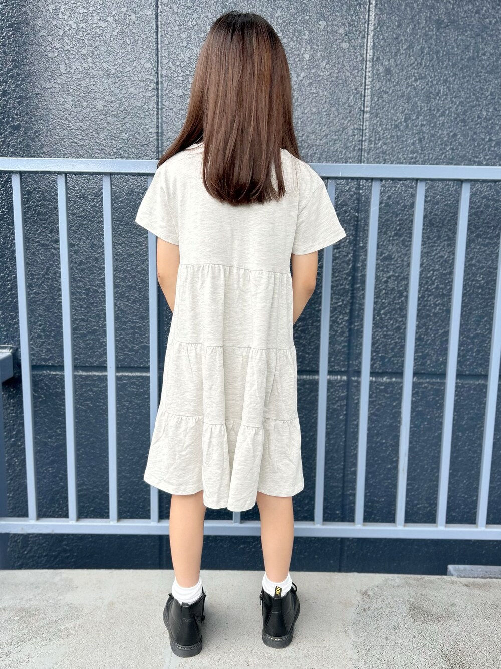 シルバー系のショルダーバッグ、ホワイト系のルームワンピースを着用したキッズの夏コーディネートの4枚目の写真
