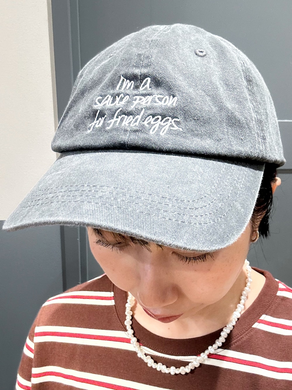 ブルー系のデニムパンツ、ブラック系のショルダーバッグ、ブラック系のキャップを着用したレディースの夏コーディネートの9枚目の写真