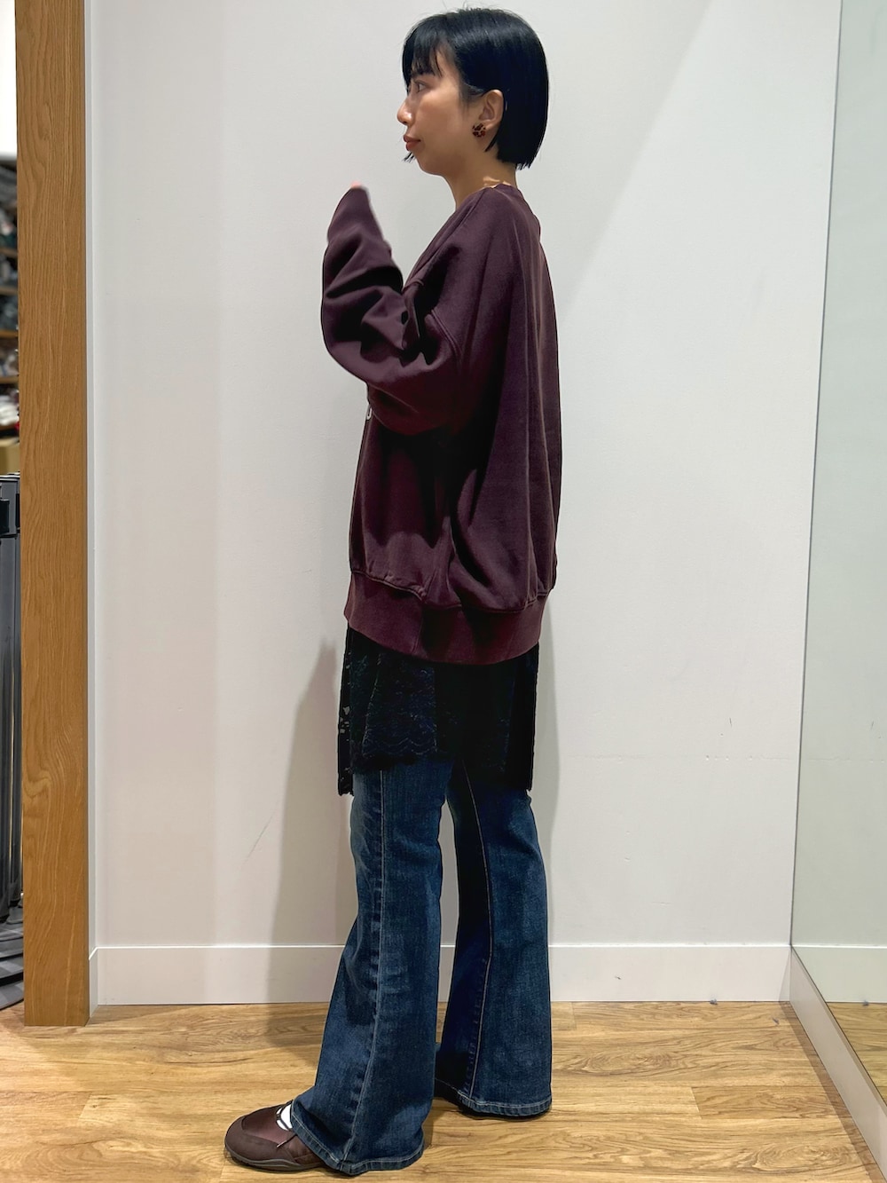 レッド系のスウェット、ブルー系のその他パンツ、ブラック系のショルダーバッグを着用したレディースの秋コーディネートの2枚目の写真